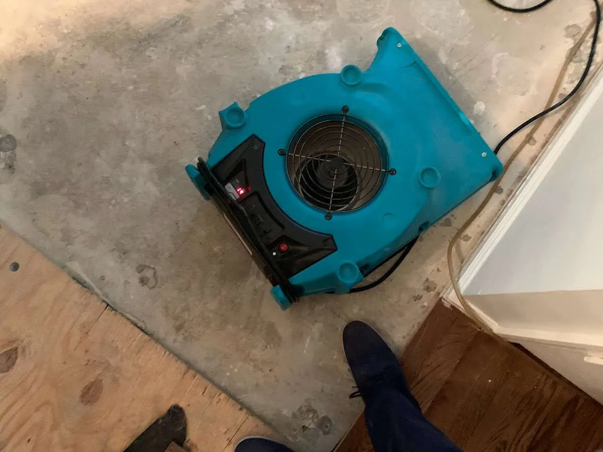 Air mover drying subfloor during Commercial Water Damage Restoration in Le Roy